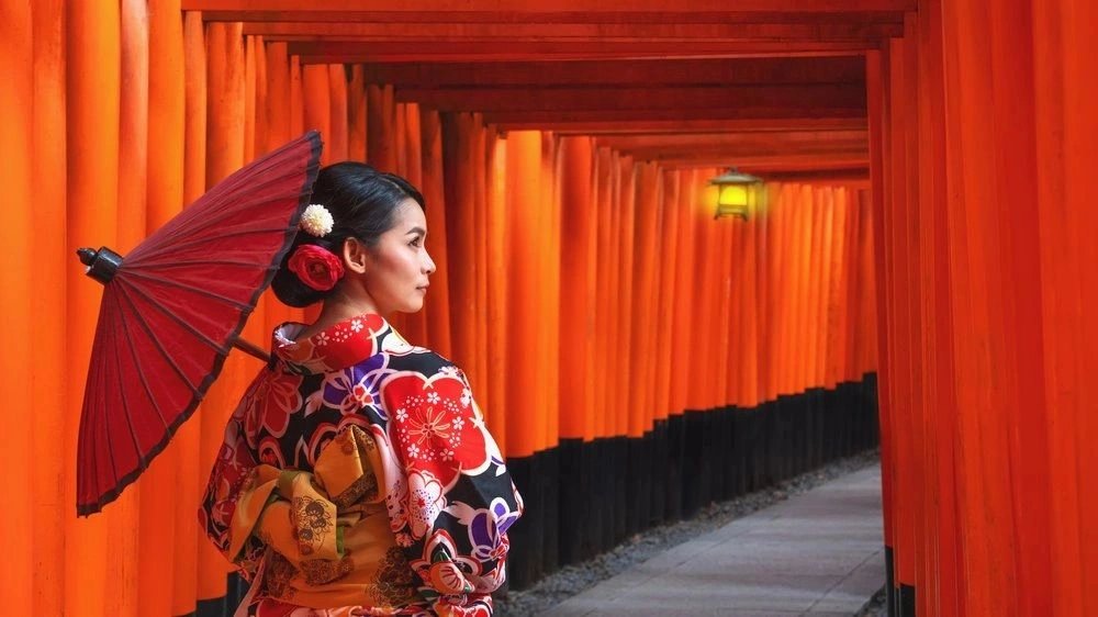 Vermilion shrine gates and traditional dress in Kyoto