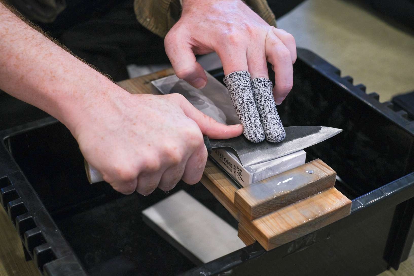 Japanese knife workshop with sharpening stones and finished kitchen knives