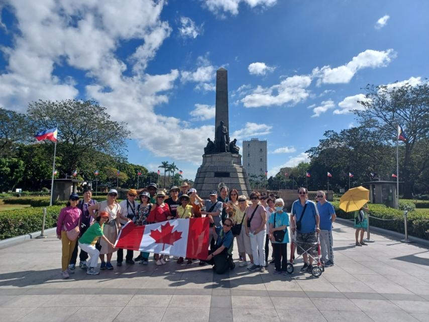 Guests gathered at a monument with a Canadian flag